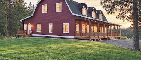 A large, two-story house with a red exterior and a covered porch.