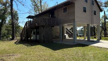 A two-story building with a covered porch and a staircase leading to an upper level.