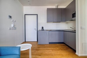 A modern kitchen with grey cabinets, a white countertop, and a built-in oven. - Bright 1BR near to the center of Milan (Milano)