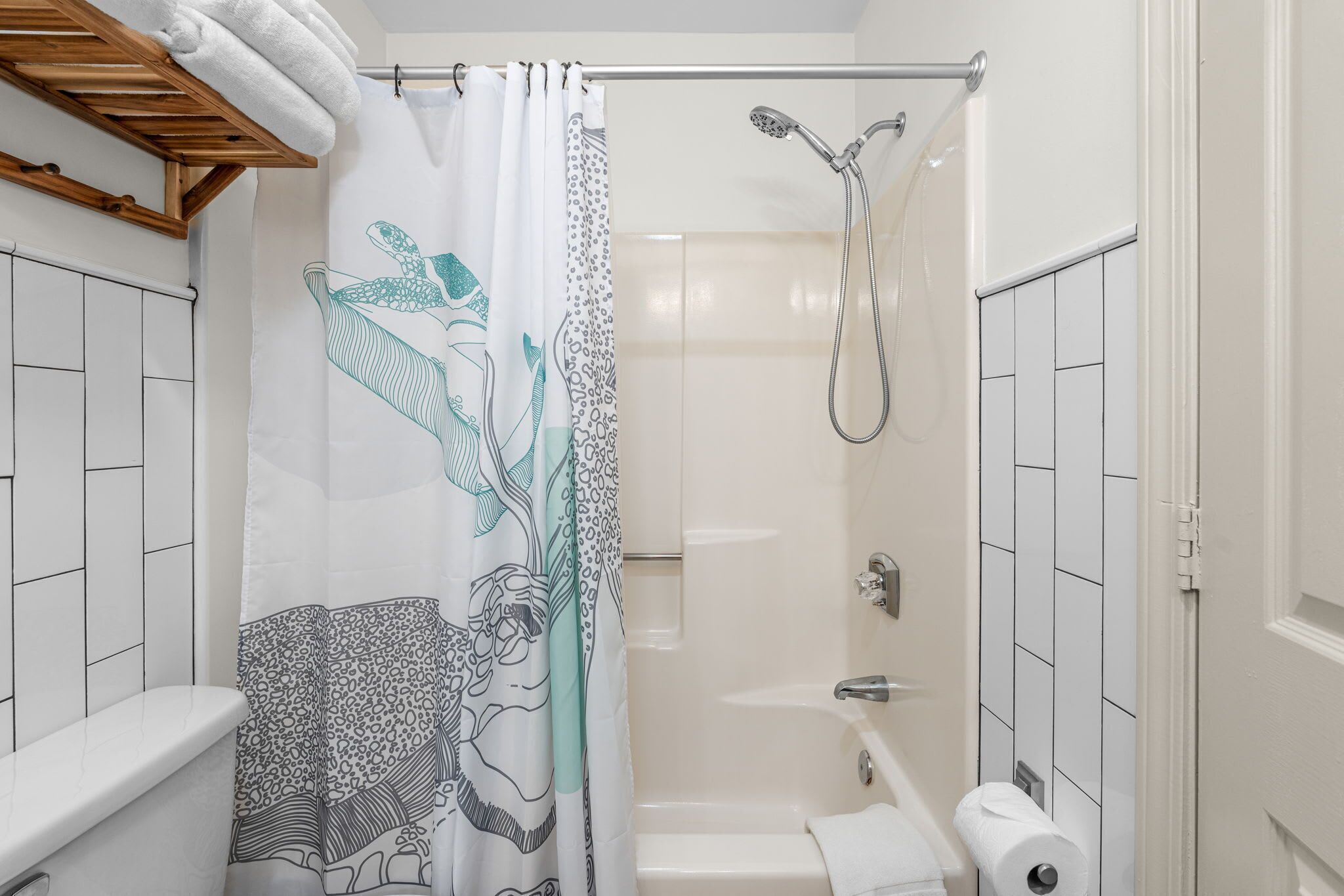 A bathroom with a shower, toilet, and bathtub.