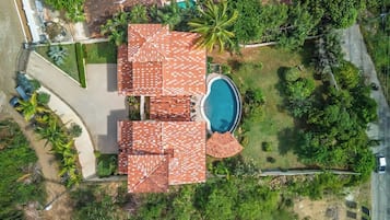 Il s’agit d’une propriété résidentielle dotée d’une piscine, de plusieurs espaces couverts et d’un jardin luxuriant.