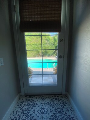 Eine Tür, durch ein Fenster mit Blick auf einen Pool.