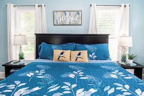 A bedroom with a bed, two nightstands, a wall decoration, and a window with curtains. - Quiet Palm Loft Near Lake w/ BBQ & Patio (Lakeland)