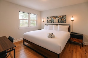 A hotel room with a large bed, two bedside tables, a desk, and a window. - 2bd 1 Bth Apt. (Denver)
