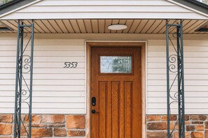 A house with a wooden door, a number '5353' on the wall, and a stone foundation. - 2Bd 1Bth Apt. | 100"TV | 3GB WIFI (Denver)