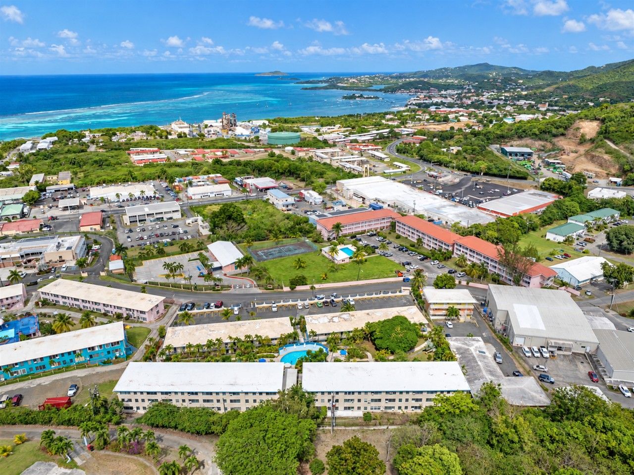 An aerial view of a coastal town with buildings, roads, and a beach.