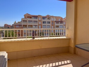 Ein Balkon mit Blick auf ein mehrstöckiges Gebäude mit Balkonen.