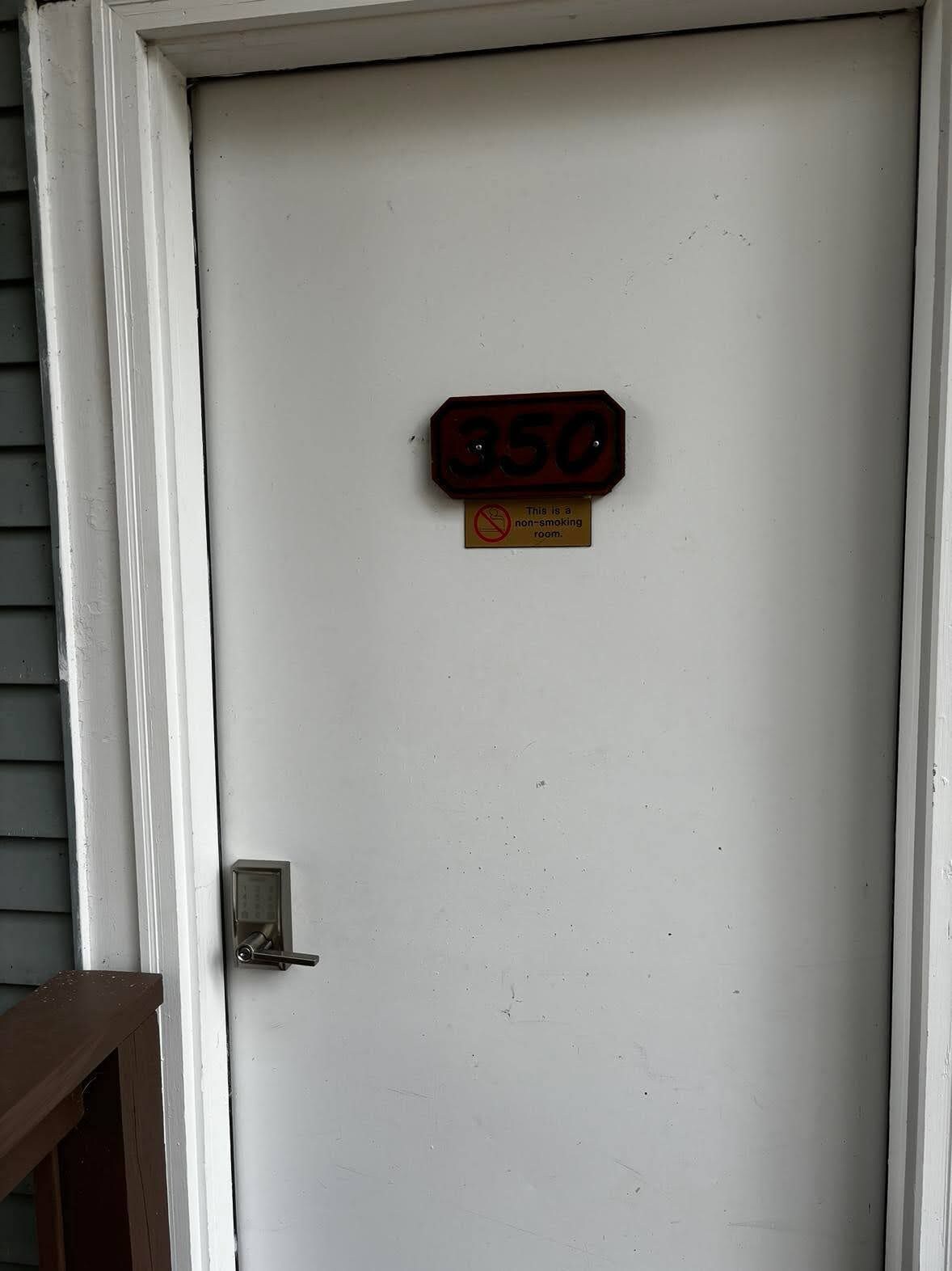 A white door with a number plate reading '350' and a non-smoking sign below it.