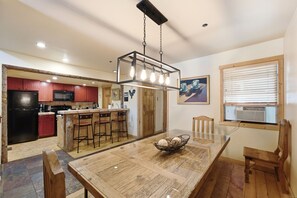 Eine moderne Küche mit roten Schränken, einem schwarzen Kühlschrank und einer Bar mit Barhocker.