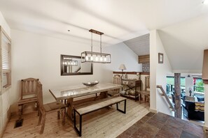 A dining area with a wooden table, benches, a hanging light fixture, and a mirror on the wall. - New Listing! Pet Friendly Townhome - Fenchurch Trails (Park City)