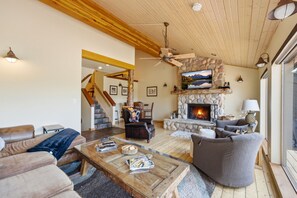 A spacious living room with a stone fireplace, leather furniture, and a ceiling fan. - New Listing! Pet Friendly Townhome - Fenchurch Trails (Park City)