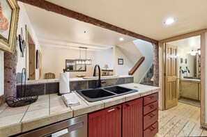 A kitchen with a double sink, red cabinets, and a stone backsplash. - New Listing! Pet Friendly Townhome - Fenchurch Trails (Park City)