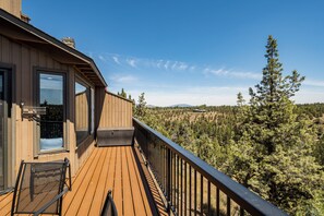A wooden deck with a view of a forested landscape. - Bird House on the beautiful Deschutes River. Dog Friendly (Redmond)