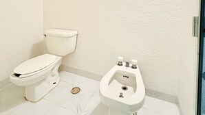 Un baño con inodoro y bidé.