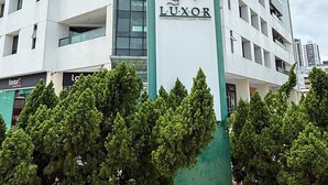 A multi-story building with a sign reading 'LUXOR CONDOMINIO LUXOR TAMBAU'. - Luxor Tambau (João Pessoa)