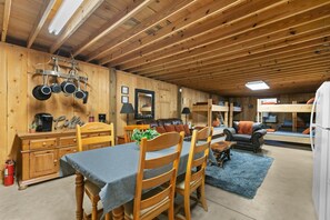 Un intérieur de chalet chaleureux comprenant un coin repas, une cuisine et un espace de vie.