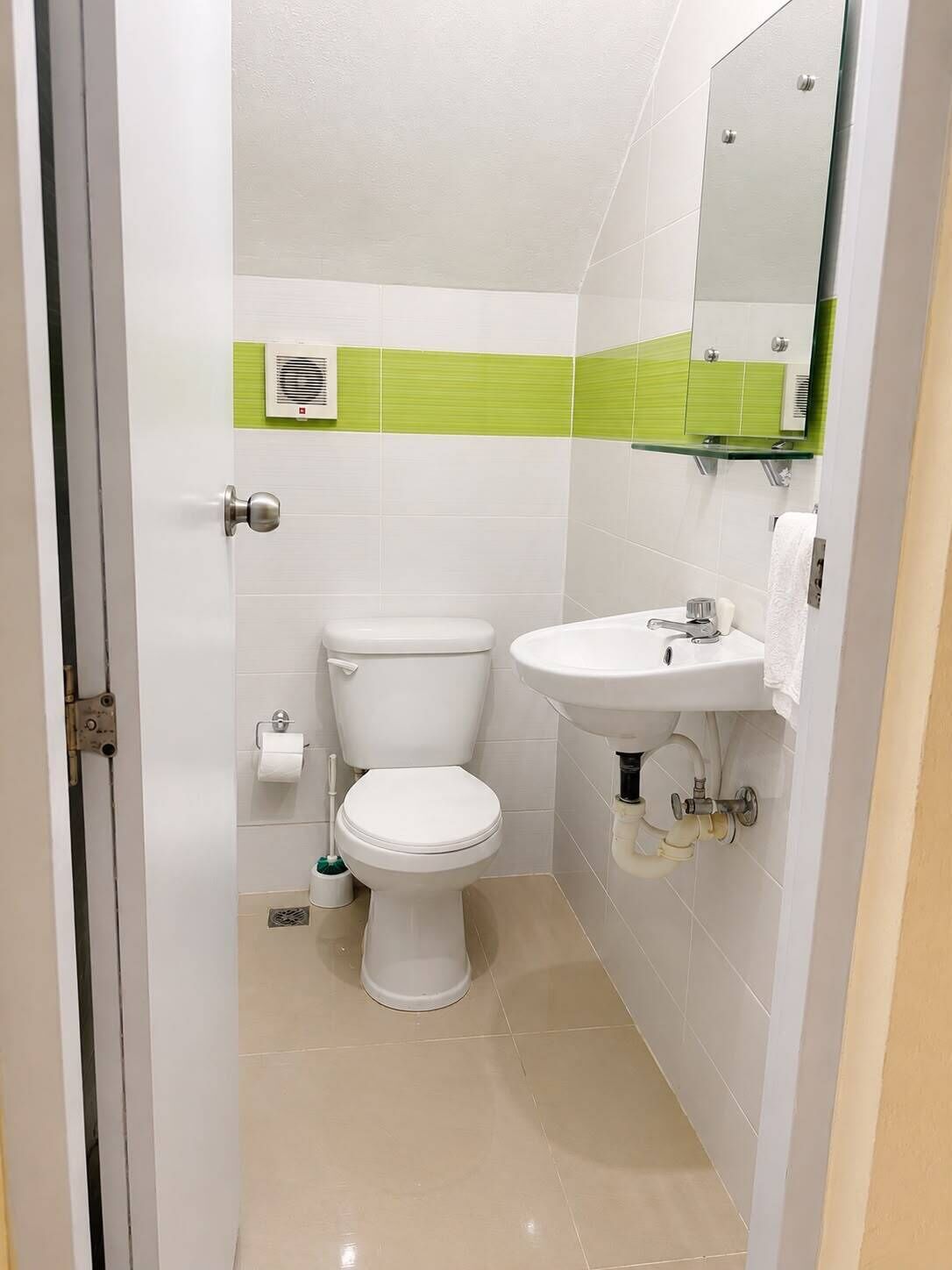 Une salle de bain avec des toilettes, un lavabo et un miroir.
