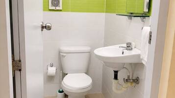 Une salle de bain avec des toilettes, un lavabo et un miroir.