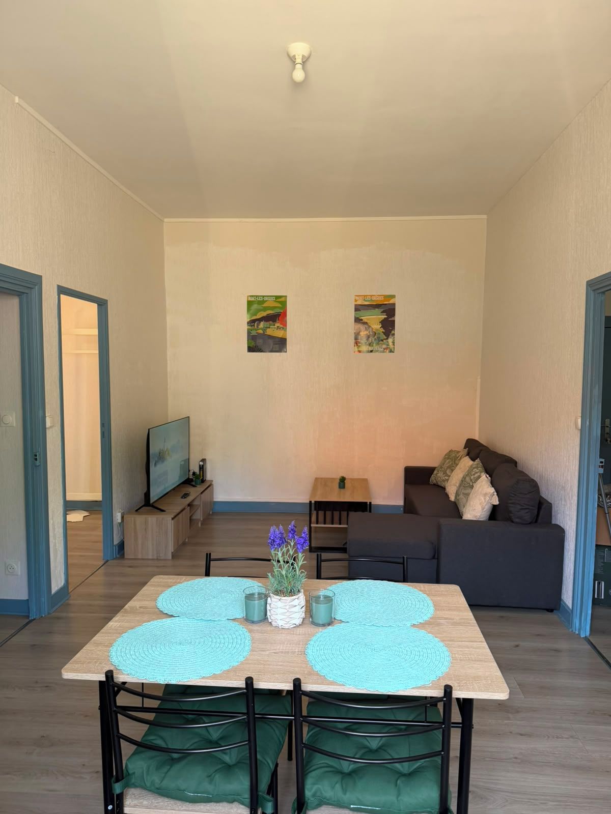 Un espace de vie moderne comprenant une table à manger, des chaises, un canapé et des œuvres d’art accrochées aux murs.