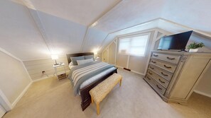 Un dormitorio con cama, mesita de noche, lámpara, cómoda y ventana.