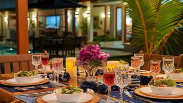 A dining table set with multiple plates, glasses, and a centerpiece of flowers.