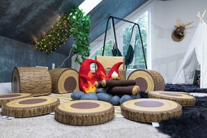 A cozy indoor setting with a hammock, a plush toy, and a tent-like structure.