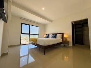 A modern bedroom with a large bed, a nightstand, a lamp, and a view through a large window. - Spectacular Oceanview Escape in Torre 5 | Minutes to Centro! (Mazatlan)