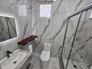 Een douche, handdoeken, zeep, toiletpapier