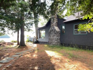 A cabin with a stone chimney, a wooden staircase, and a view of a lake. - Lakefront 4-bedroom property with spectacular views of Blue Mountain Lake. (Blue Mountain Lake)