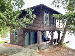 A wooden cabin with a porch, a door, and a window.
