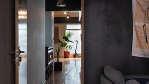 A hallway with a wooden floor, a potted plant, and a bicycle. - Casa Maryna. (Villa de Cos)