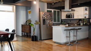A modern kitchen with a central island, bar stools, a refrigerator, and a microwave. - Casa Maryna. (Villa de Cos)