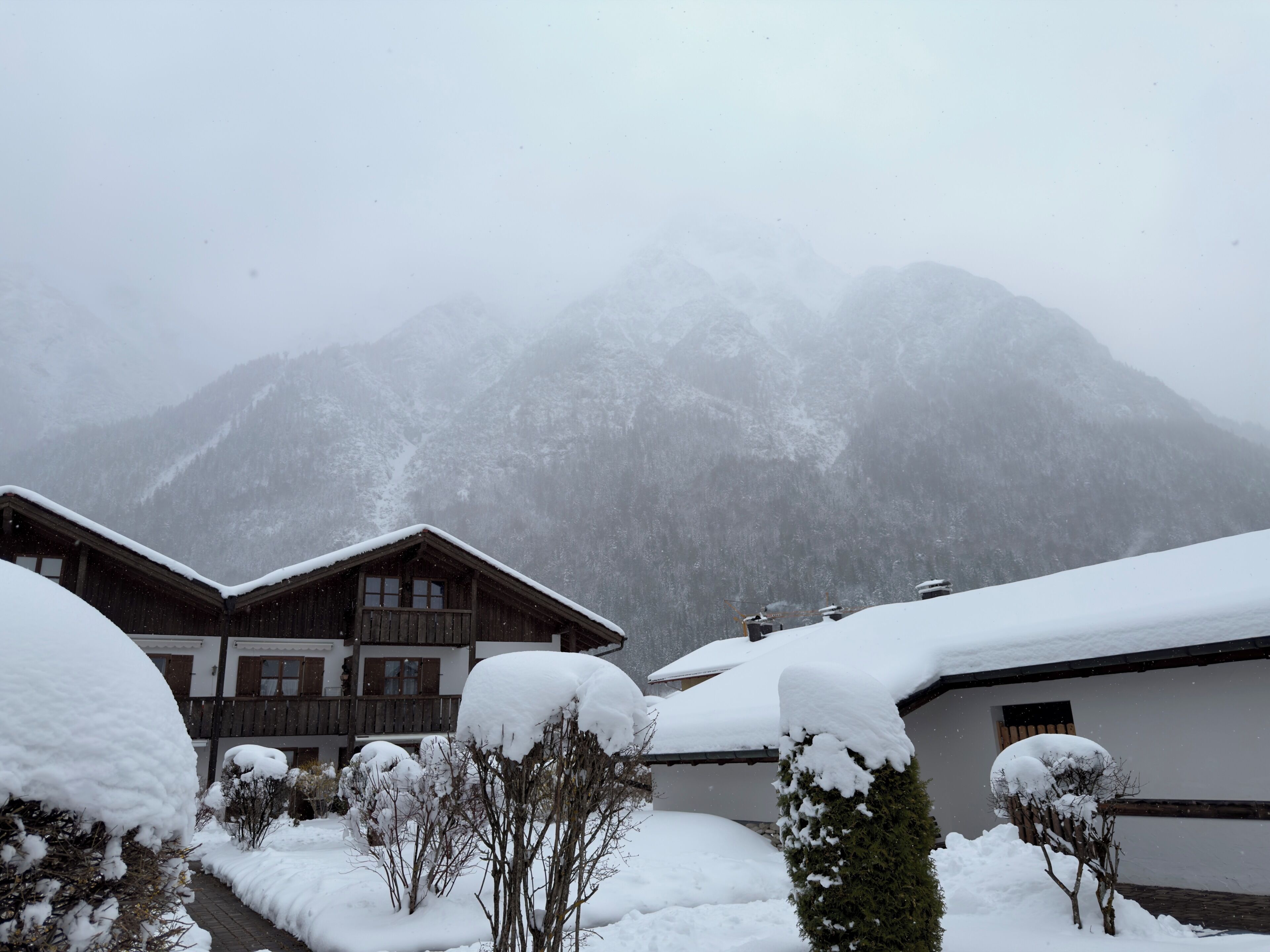 A snow-covered mountain landscape with wooden buildings and a clear sky.