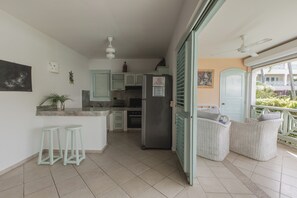 A kitchen with a refrigerator, sink, and bar stools. - Bamboo House, Oceanfront, Las Terrenas, Punta Popi. Comfort, convenience, and magic. (Las Terrenas)