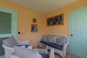 A room with a white wicker sofa, two grey armchairs, a small table, and a painting on the wall. - Bamboo House, Oceanfront, Las Terrenas, Punta Popi. Comfort, convenience, and magic. (Las Terrenas)