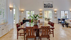 A spacious dining area with a long wooden table and chairs, a woven plant centerpiece, and a chandelier. - Tortuga C20 Luxury 5-Bedroom Villa at the Punta Cana Resort (Punta Cana)