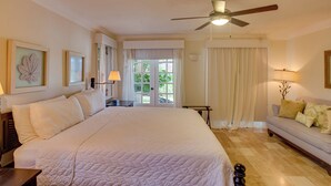 A hotel room with a large bed, a ceiling fan, a sofa, and a view of the outdoors. - Tortuga C20 Luxury 5-Bedroom Villa at the Punta Cana Resort (Punta Cana)