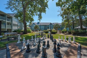 A chessboard set up outdoors with a building in the background. - Myrtle Beach Resort Ocean View Condo (Myrtle Beach)
