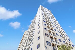 Un immeuble de grande hauteur doté de nombreux balcons, avec un ciel dégagé.