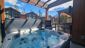 A hot tub with jets, a grill, and a view of houses and trees. - Pet-Friendly Panorama Escape / Hot Tub / Sleeps 10 (Panorama)