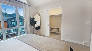 A bedroom with a large window, a bed, a mirror, and a closet. - Pet-Friendly Panorama Escape / Hot Tub / Sleeps 10 (Panorama)