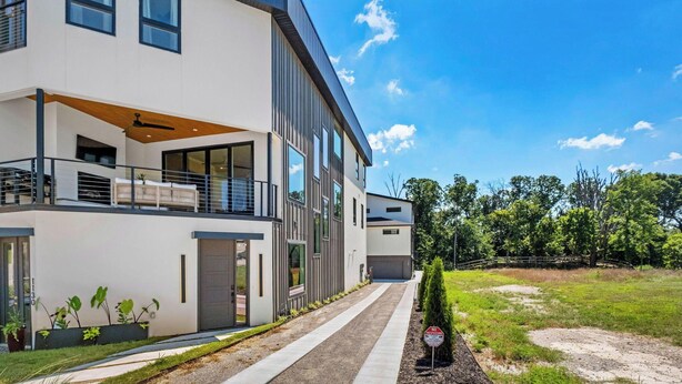 Une maison moderne à deux étages, dotée d’un balcon, d’une allée et d’un panneau indiquant « Entrée interdite ».
