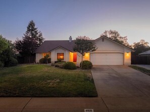A residential house with a garage, a driveway, and a well-maintained lawn. - Newly remodeled, stunning Italian 3BR/3BA cottage with pool, RV parking/hookups (Redding)