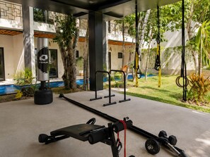 An outdoor gym area with exercise equipment, including a punching bag, pull-up bar, and weight bench. - Modern Tulum Penthouse ● Private Plunge Pool ● Fast WiFi ● Gym (Tulum)