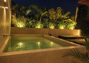 A rectangular hot tub with a wall-mounted faucet, surrounded by lush greenery and palm trees, indicating a serene outdoor setting. - Modern Tulum Penthouse ● Private Plunge Pool ● Fast WiFi ● Gym (Tulum)