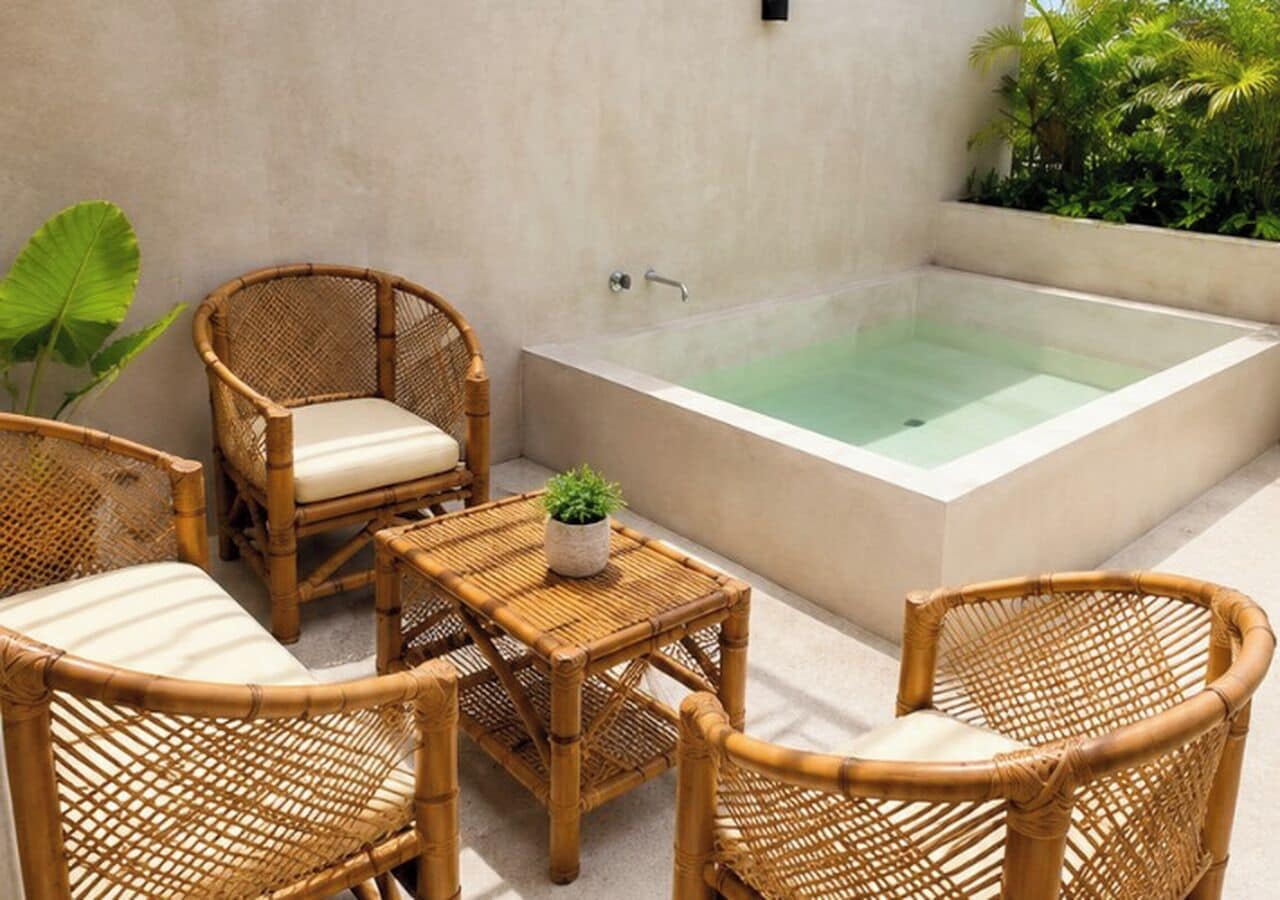 A spa area with a hot tub, wicker furniture, and a small table with a plant.