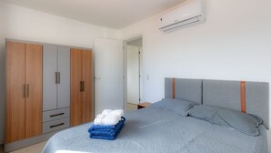 Un dormitorio con cama, armario y aire acondicionado.