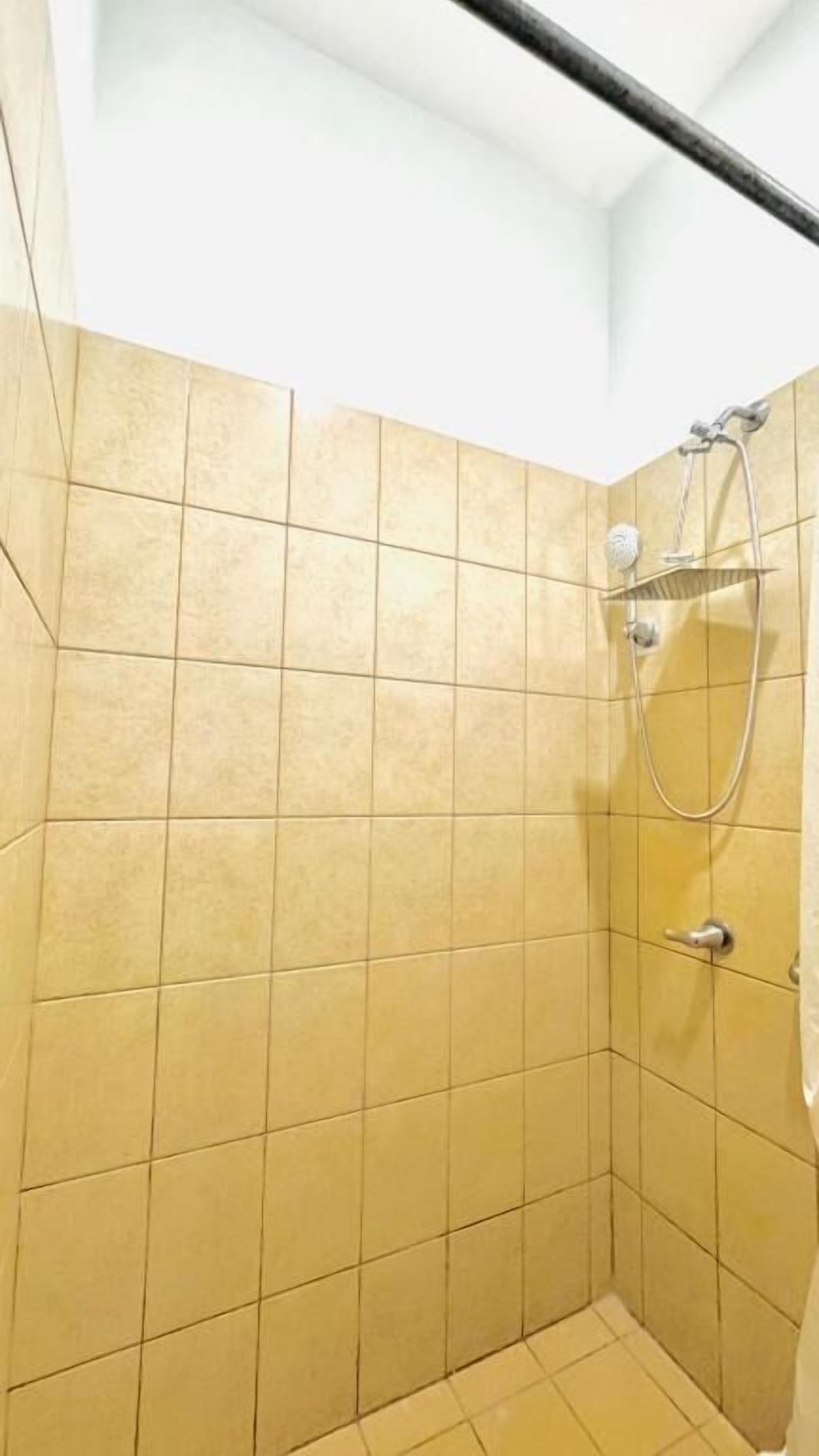 A shower area with tiled walls and a showerhead.
