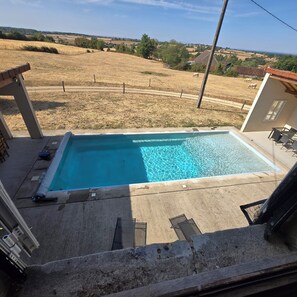 Ein rechteckiger Pool mit klarem, blauem Wasser, umgeben von einer Betonplattform.