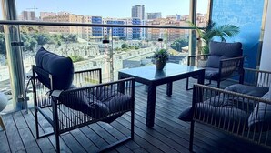 Ein Balkon mit Blick auf die Stadtlandschaft, ausgestattet mit einem Tisch und Stühlen.